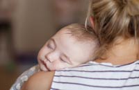 Baby's head resting comfortably on their mother's shoulder | Copyright Bright Photography