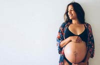 Happy pregnant woman holding her belly